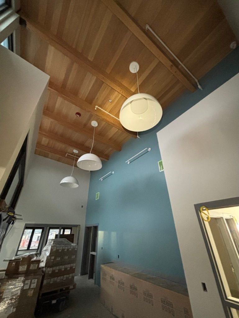 Dome pendant fixtures hung from a wood ceiling in a double-height space at the Vancouver, WA DSHS clinic