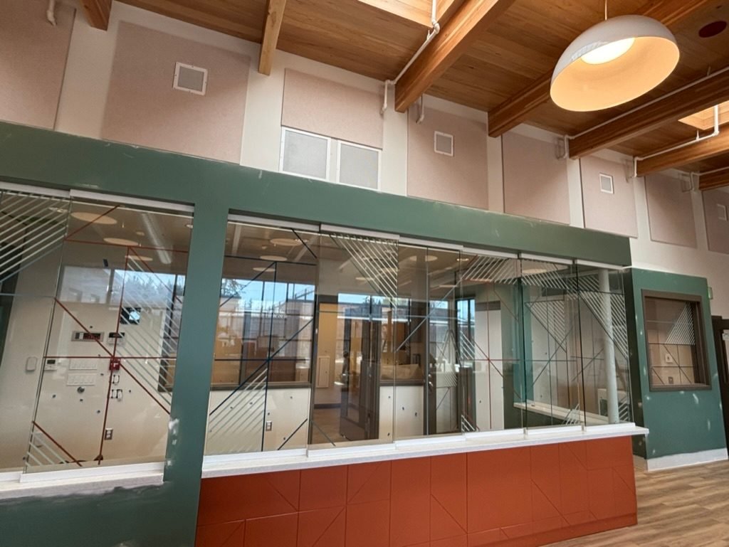 Reception counter with glass partition and acoustic wall panels at the DSHS clinic in Vancouver, WA