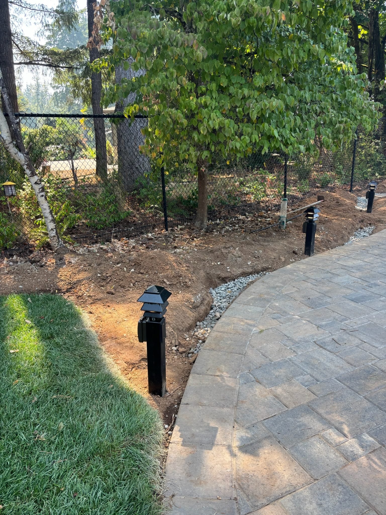 Path lights installed along a curved paver edge next to a lawn in Oregon City, OR