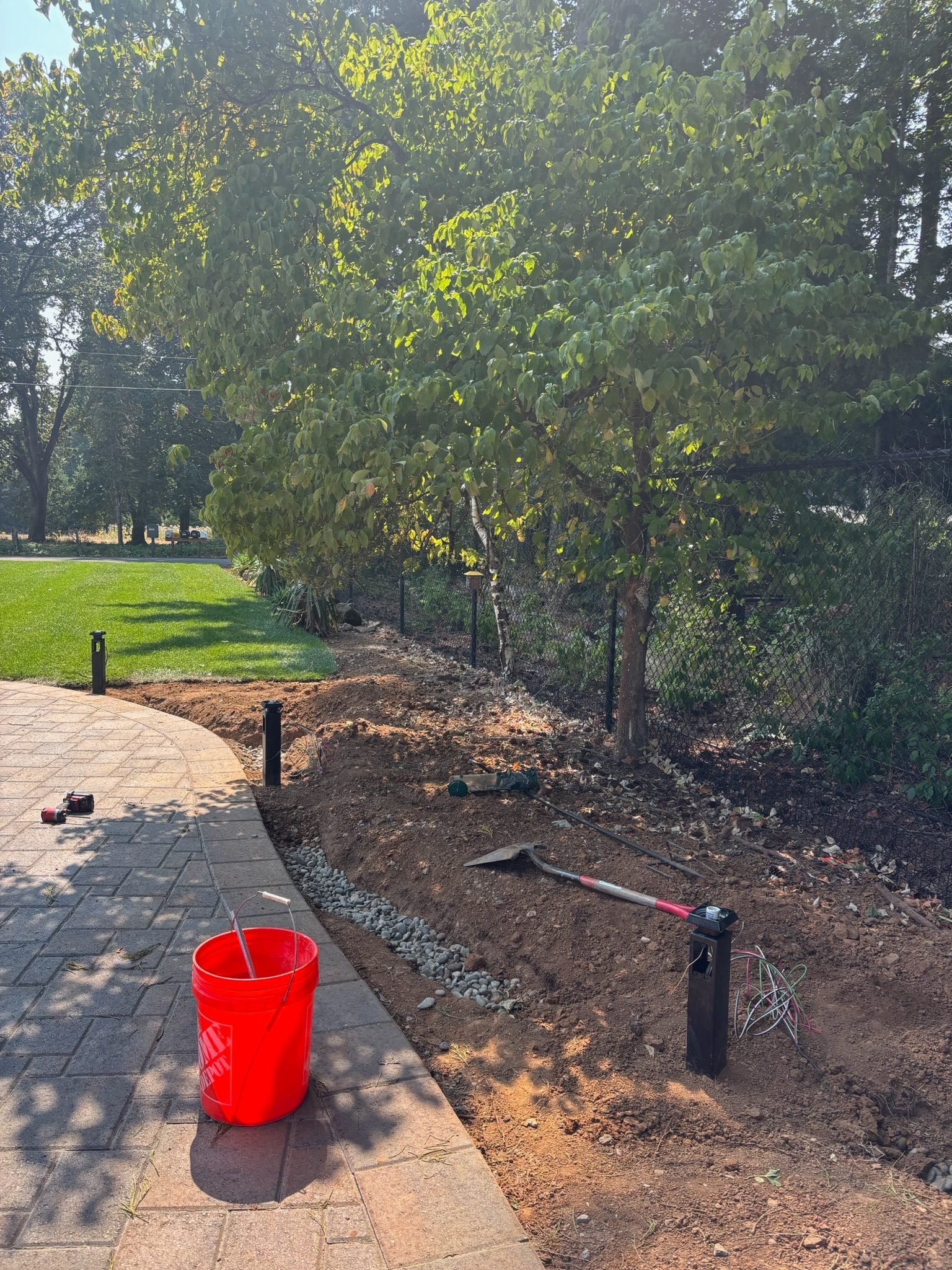 Light post with wiring exposed during installation of landscape lighting along a paver path in Oregon City, OR